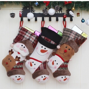 Detailed view of three hanging Christmas stockings with Santa, Snowman and Reindeer dolls