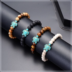 Macro shot of beaded turtle bracelets in tiger eye, lava rock, and white stone textures