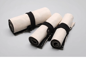 Roll-up canvas pencil case with black cotton ties and inner lining for art supplies