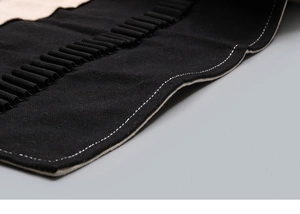 Detailed close-up of canvas texture and elastic slots on the black pencil wrap