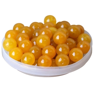 Polished yellow natural jade loose beads in a white tray for DIY jewelry making