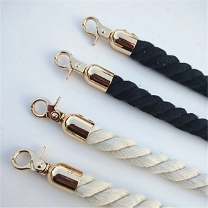 Detail of twisted velvet stanchion ropes in black and beige with gold metal spring hooks