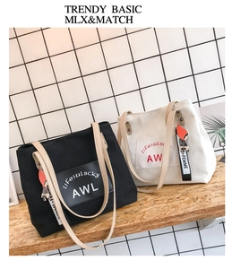 Detail view of canvas tote bags with contrast straps, brand patches, and character charms