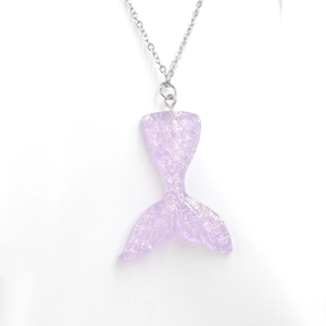 Detail shot of a purple translucent mermaid tail pendant with glitter and fish scale texture