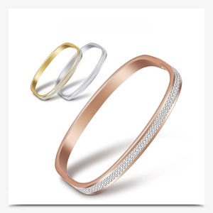 Detail view of gold, silver, and rose gold square bangles with two-row pavé crystals