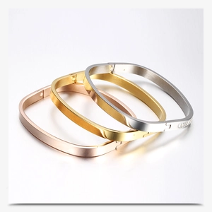 Close-up of three-color stainless steel square bangles with sparkling rhinestone accents
