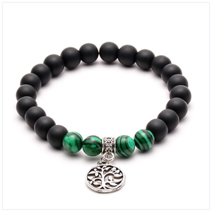 Detail of beaded yoga bracelet featuring matte black stones and Tree of Life charm