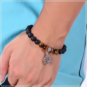 Close-up of lava rock and tiger eye beaded bracelet with Tree of Life charm on wrist