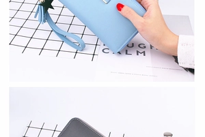 Detail of long zippered leather wallets with star fringe tassel and wrist strap handle