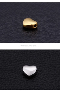 Macro detail of polished heart-shaped stainless steel beads with side-drilled holes
