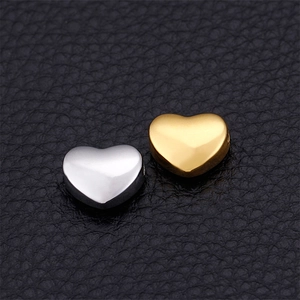 Polished heart-shaped stainless steel beads in gold and silver finish on leather