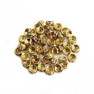 Macro shot of gold-plated wheel spacers with white rhinestones for DIY jewelry