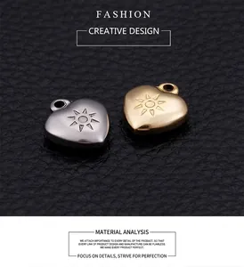 Macro shot of gold and silver stainless steel heart pendants with sunburst engraving