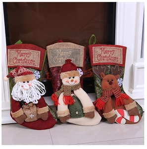 Close-up of Santa, Snowman, and Reindeer burlap Christmas stockings by a cozy fireplace