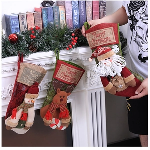 Close-up of Santa, elk, and snowman Christmas stockings on a fireplace mantle