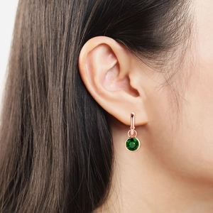 Elegant rose gold earrings with round green zircon drop pendant on model ear