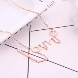 Rose gold LOVE letter titanium steel necklace displayed on a decorative ceramic plate