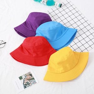 Flat lay of colorful cotton bucket hats in purple, blue, red and yellow for sun protection