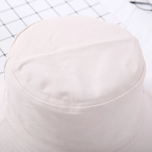 Close-up of beige cotton bucket hat showing detailed twill texture and stitching
