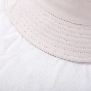 Close-up of beige twill cotton bucket hat showing parallel stitching and fabric texture