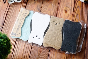 Close-up of 4-pack cat-shaped kitchen sponges showing three-layer structure on wood desk