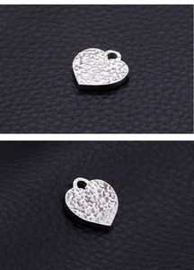 Macro detail of silver stainless steel heart pendant with unique hammered texture
