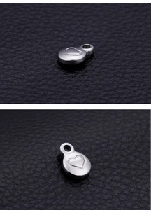 Macro shot of silver oval stainless steel pendant with engraved heart pattern detail