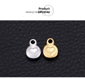Close-up of gold and silver heart-shaped stainless steel pendants on leather background