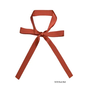 Detail des rostroten Satin-Schals, als dekorativer Knoten auf weißem Grund gebunden
