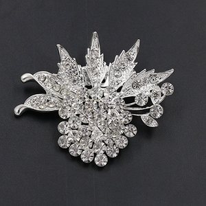 Detailed close-up of a silver floral alloy brooch with sparkling crystal rhinestones