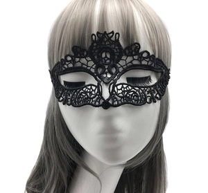 Close-up of black lace masquerade mask with intricate cutout patterns on a white mannequin