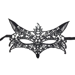 Close-up of black lace masquerade mask with intricate cutout patterns and silk ribbons