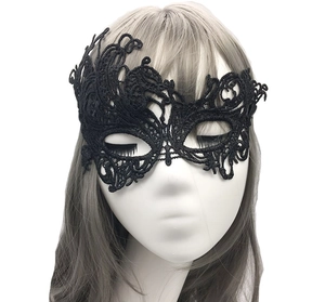 Detail shot of black lace masquerade mask with intricate patterns on a mannequin head