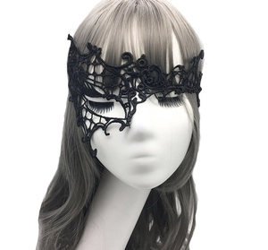 Detail of elegant black lace masquerade mask with intricate hollow patterns on model