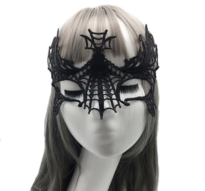 Detail of black lace masquerade mask with spider web pattern on a female model