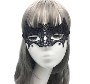 Macro detail of bat-wing black lace masquerade mask with intricate hollow patterns