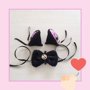 Detail of plush black cat ears and bow tie set with pink lining and golden bells