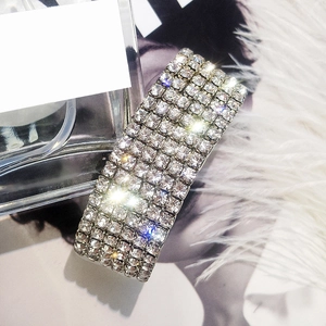 Detail of wide metal hair clip featuring ten rows of square shimmering rhinestones