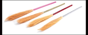 Macro shot of Halloween mini witch brooms with sparkling pink gold red and silver handles