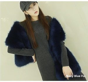 Detail of navy faux fox fur shawl with black tips draped over an elegant grey dress