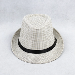 Detail of light beige woven fedora featuring black satin ribbon and metal buckle