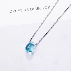 Minimalist silver chain necklace featuring a transparent light blue teardrop crystal pendant