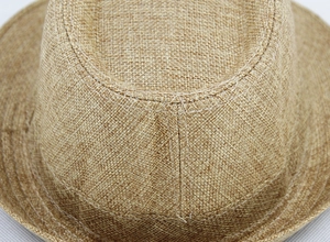 Close-up of cross-stitch detail on a woven straw sun hat with textured fiber