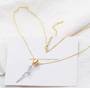 Close-up of elegant gold and silver rose pendant on a fine necklace chain with S925 stamp