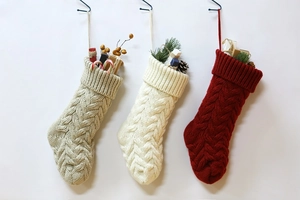 Close-up of knitted Christmas stockings with cable knit texture and festive fillers