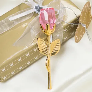Elegant pink crystal rose with golden metal leaves in a romantic heart gift box