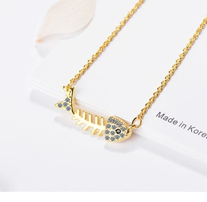 Macro shot of gold fishbone pendant with sparkling white rhinestones and fine craftsmanship