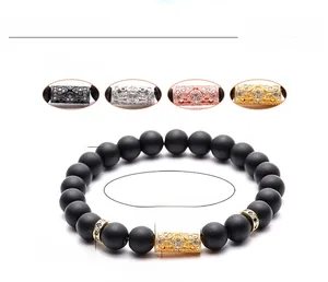 Macro detail of 8mm matte black stone beads with micro-inlaid zircon crown and tube charms
