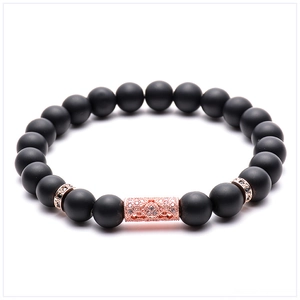 Detailed view of matte black onyx beads with rose gold micro-pave zircon cylinder charm