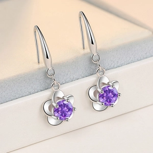 Elegant silver-plated flower earrings featuring sparkling purple zircon in a macro view